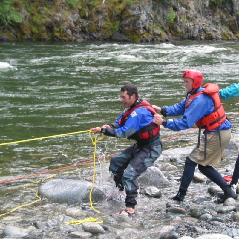 a group of people on a rock next to water