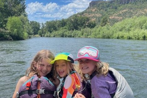 a little girl sitting in a boat on a body of water