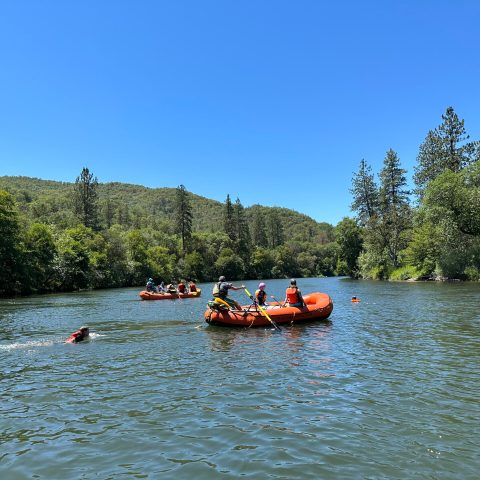 a group of people rowing a boat floating on a body of water