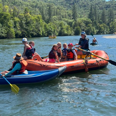 a group of people in a small boat in a body of water