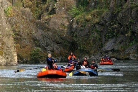 a man riding on the back of a boat in the water