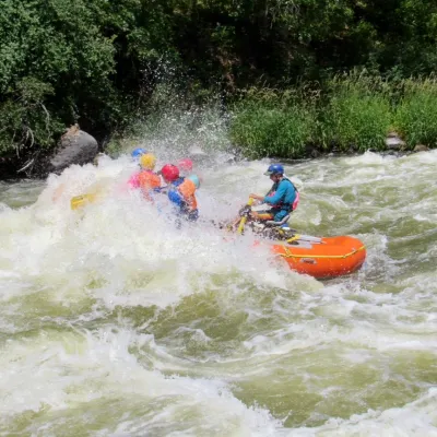 a group of people riding on a raft in a body of water