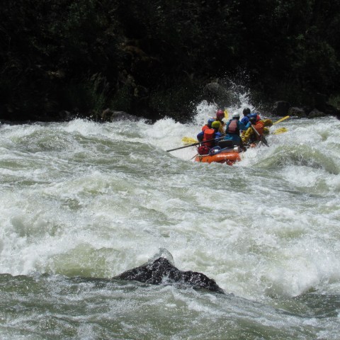 a group of people riding on a raft in a body of water