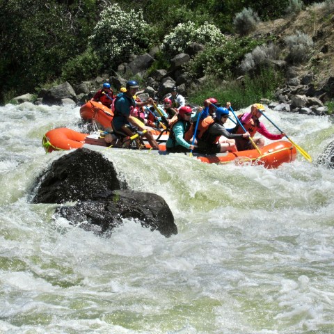a group of people riding on a raft in the water