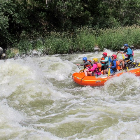 a group of people riding on a raft in a body of water