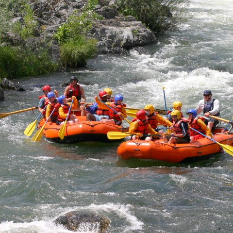 a group of people riding on the back of a boat in the water