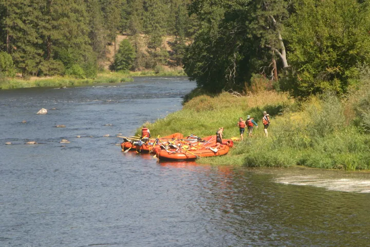 a group of people in a small boat in a body of water