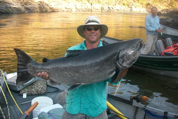 a person holding a fish on a boat in the water