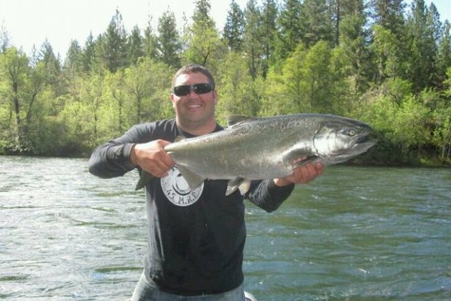 a man holding a fish in the water