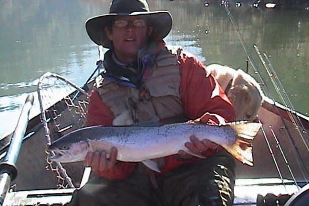 a man holding a fish on a boat