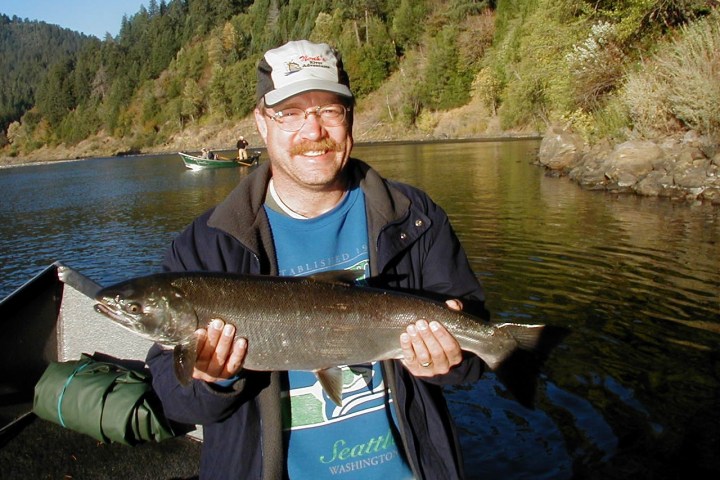 a man holding a fish in the water