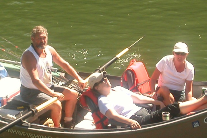 a group of people sitting in a boat on a body of water