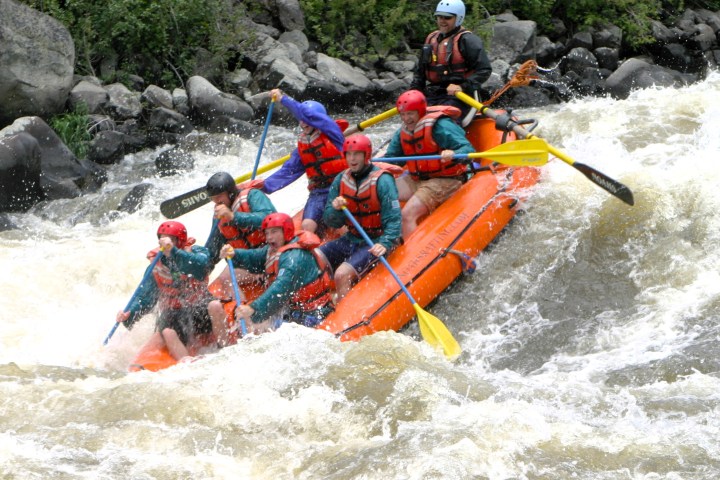 a group of people riding skis on a raft in the water